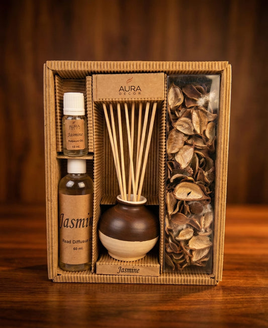 Aroma diffuser set with reeds and essential oils in a decorative box on a wooden surface.